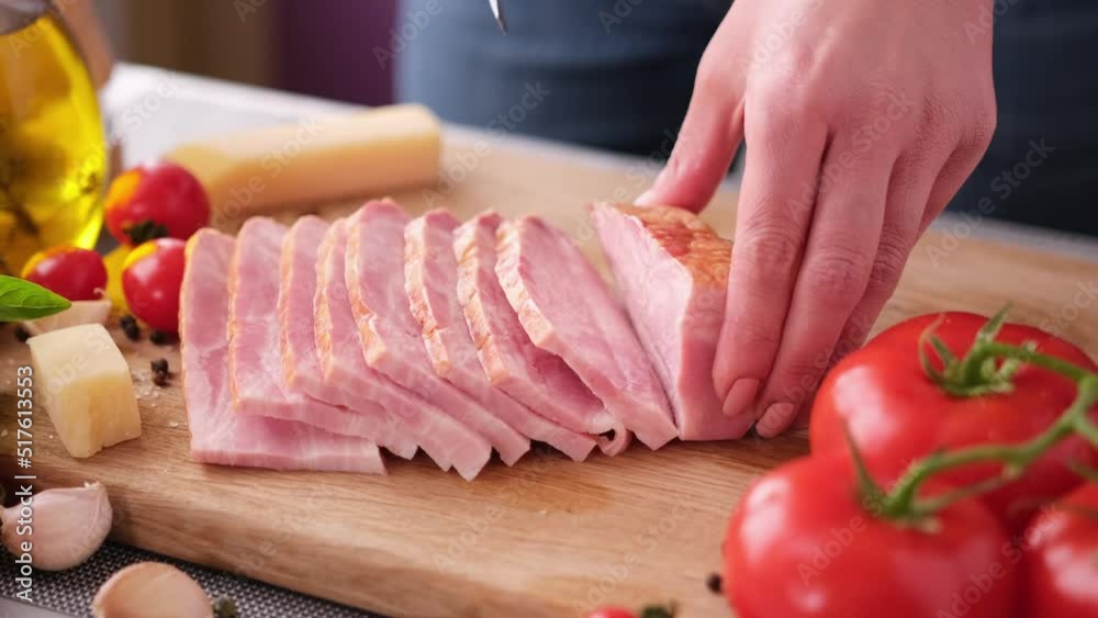 Making pasta carbonara - Slicing traditional pancetta bacon into pieces on a wooden cutting board with a knife