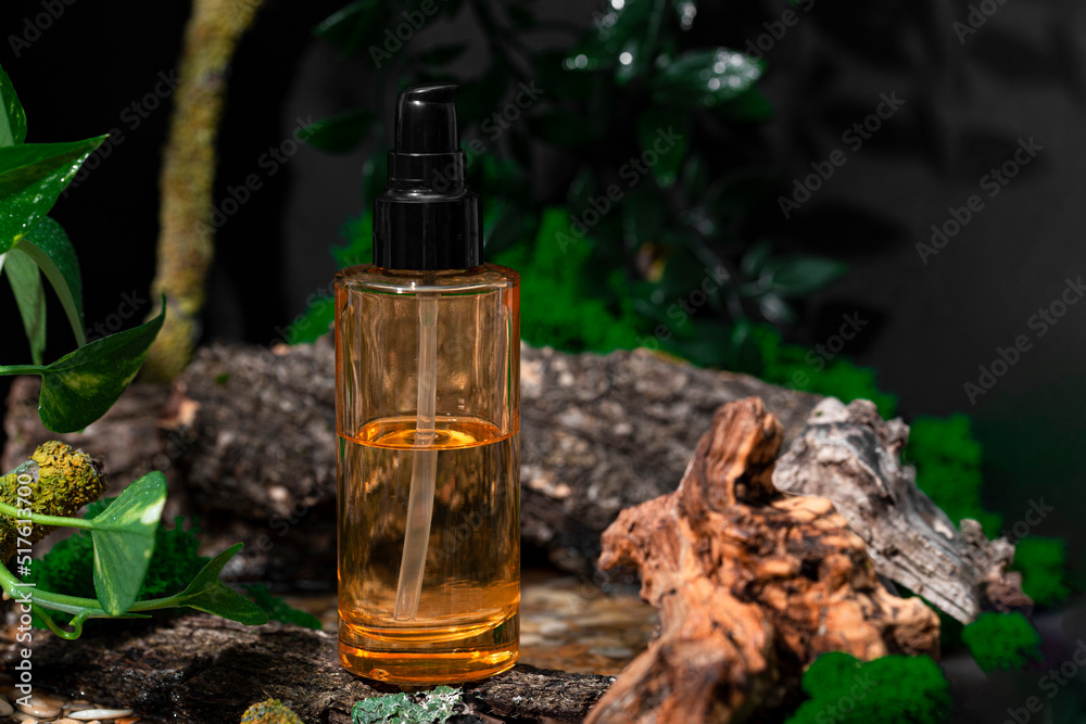 A bottle of sustainable skin care product and textured wood on a dark background. Eco cosmetics in a forest A bottle of sustainable skin care product and textured wood on a dark background. Eco cosmetics in a forest