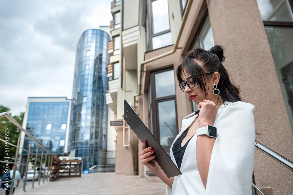 Fototapeta premium Full length photo of young attractive businesswoman outdoors in city center.