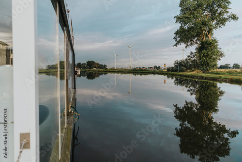 Houseboat on Yser River under cloudy sky photo