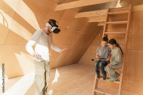 Man with 3d glasses and kids visualising home interior at new eco house