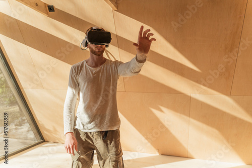 Man using 3d glasses to visualise home interior at of wooden eco house