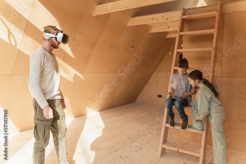 Man with 3d glasses and kids visualising home interior at new eco house photo