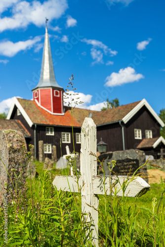 Norway, Viken, Flesberg, Medieval stave church in summer with graves in foreground photo