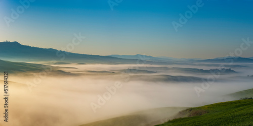 Italy, Tuscany, Volterra, Panoramic view of rolling landscape shrouded in thick morning fog