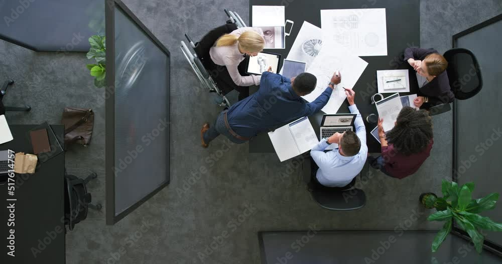 A group of architects working together on a project or building design. Top view of a diverse team of business people brainstorming in a meeting. Colleagues planning and discussing at a company