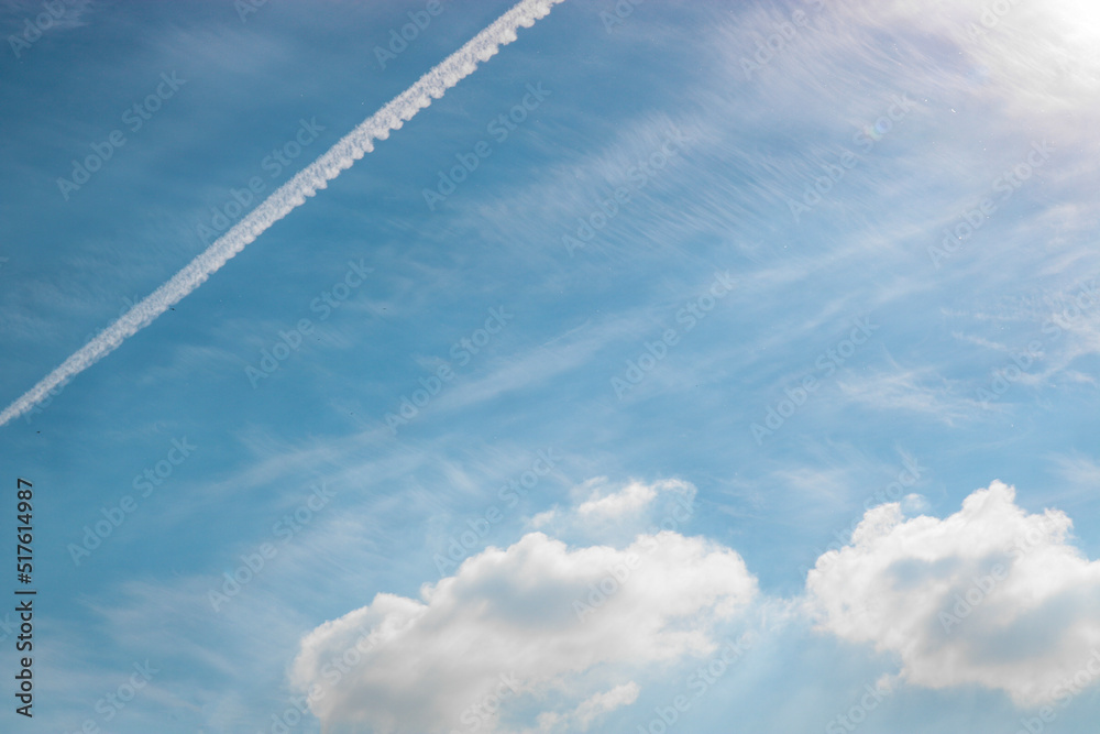 Calm blue sky and cumulus clouds, airplane trail Calm blue sky and cumulus clouds, airplane trail