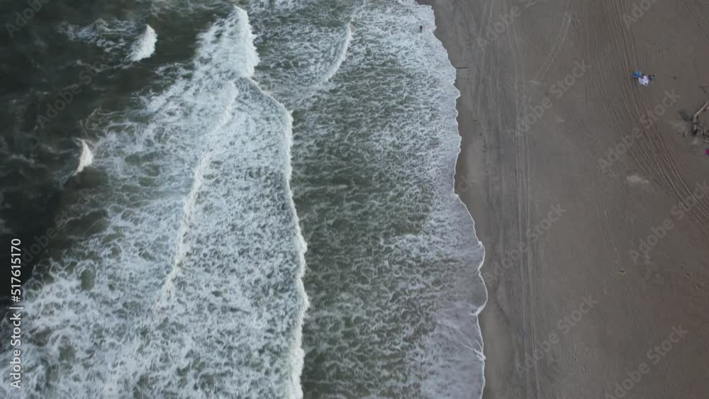An aerial view of the beach in Arverne, NY, during a beautiful and cloudy evening. The shot was taken by a drone camera that is tilted down, then dolly in and slowly tilt up over the empty beach. An aerial view of the beach in Arverne, NY, during a beautiful and cloudy evening. The shot was taken by a drone camera that is tilted down, then dolly in and slowly tilt up over the empty beach.