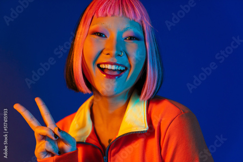 Asian girl with pink hair smiling and showing peace sign