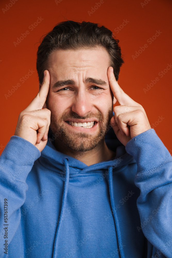 Young bristle man with headache rubbing his temples Young bristle man with headache rubbing his temples