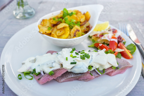 Foto Matjes or soused herring, a mild salt fish with cream sauce containing onions, g
