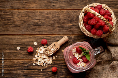 Smoothie with raspberry, oatmeal and mint in a jar on rustic wooden background.