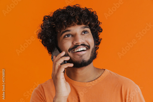 Close-up portrait of young indian smiling man talking phone