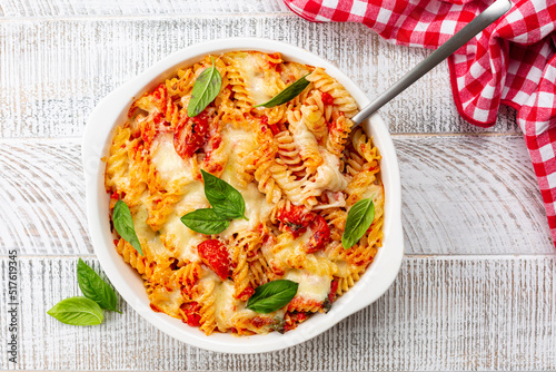 Pasta alla sorrentina.  Spiral shape fusilli pasta oven baked in casserole with tomato sauce, basil and mozzarella, parmigiano  cheese. Italian meal, Campania region. photo