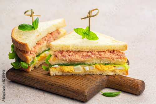 Two Tuna sandwich with boiled egg, mayonnaise, lettuce on a wooden board.
