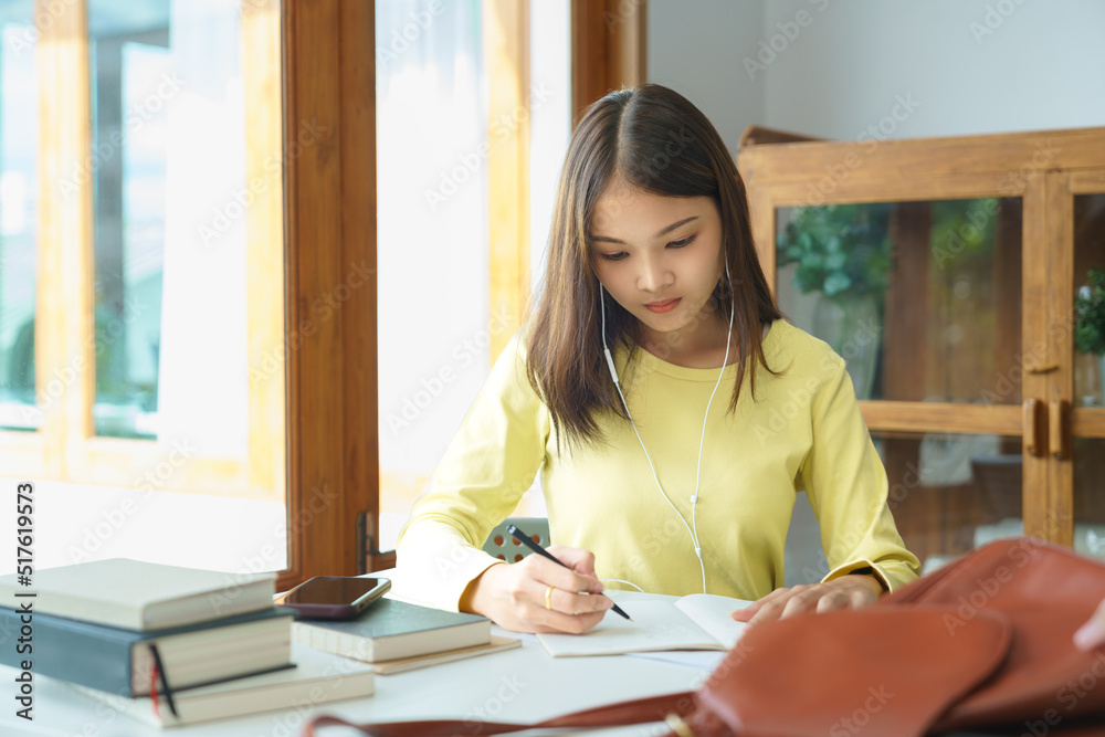 Education and literacy concept, College student girl use phone to listening lecture and taking note Education and literacy concept, College student girl use phone to listening lecture and taking note