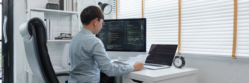 Software development concept, Male programmer read data on document while programming on computer Software development concept, Male programmer read data on document while programming on computer