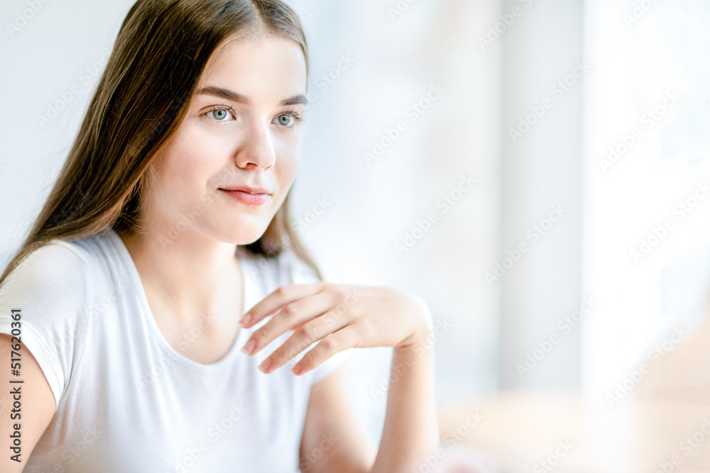 Teenage girl with hand near face sitting sitting indoor. Teenage girl with hand near face sitting sitting indoor.
