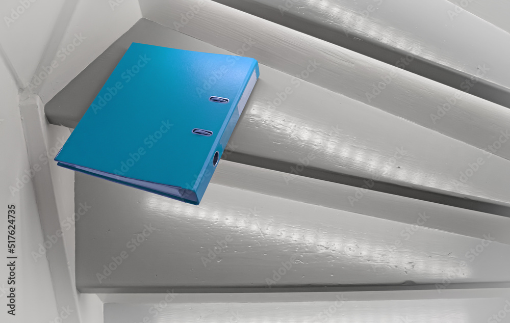 Blue file on the stairs, selective focus Blue file on the stairs, selective focus