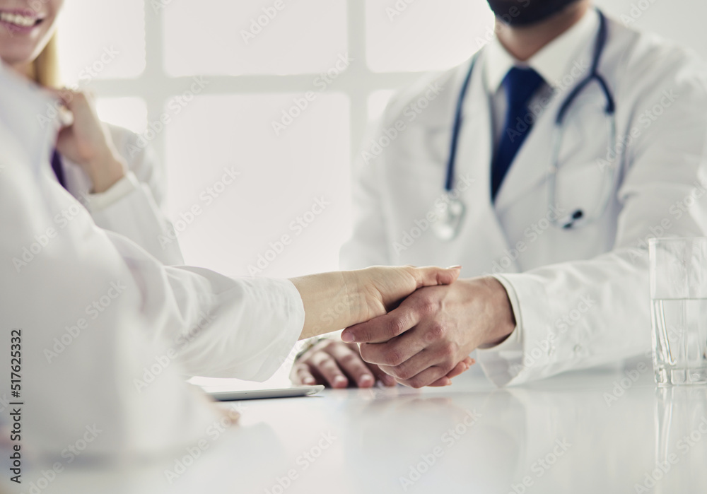 Doctor shaking hands with a male patient in the office