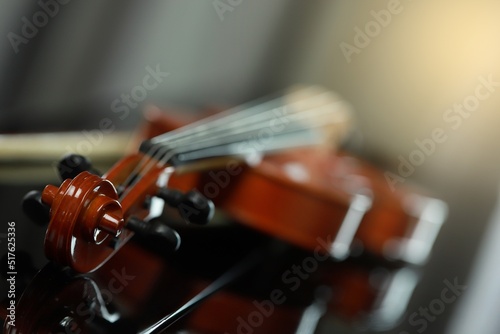 classical violin placed on piano on black background