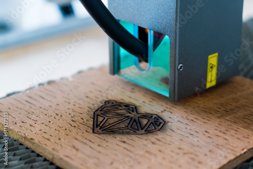 Engraving and cutting laser, example of a heart on a wooden support photo