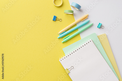 School concept. Top view photo of school supplies notebooks colorful pens binder clips and adhesive tape on bicolor yellow and white background with copyspace