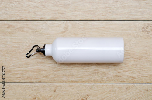 white sports metal water bottle on wooden background