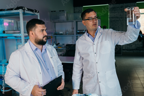 Two male laboratory assistants are doing research on chemicals