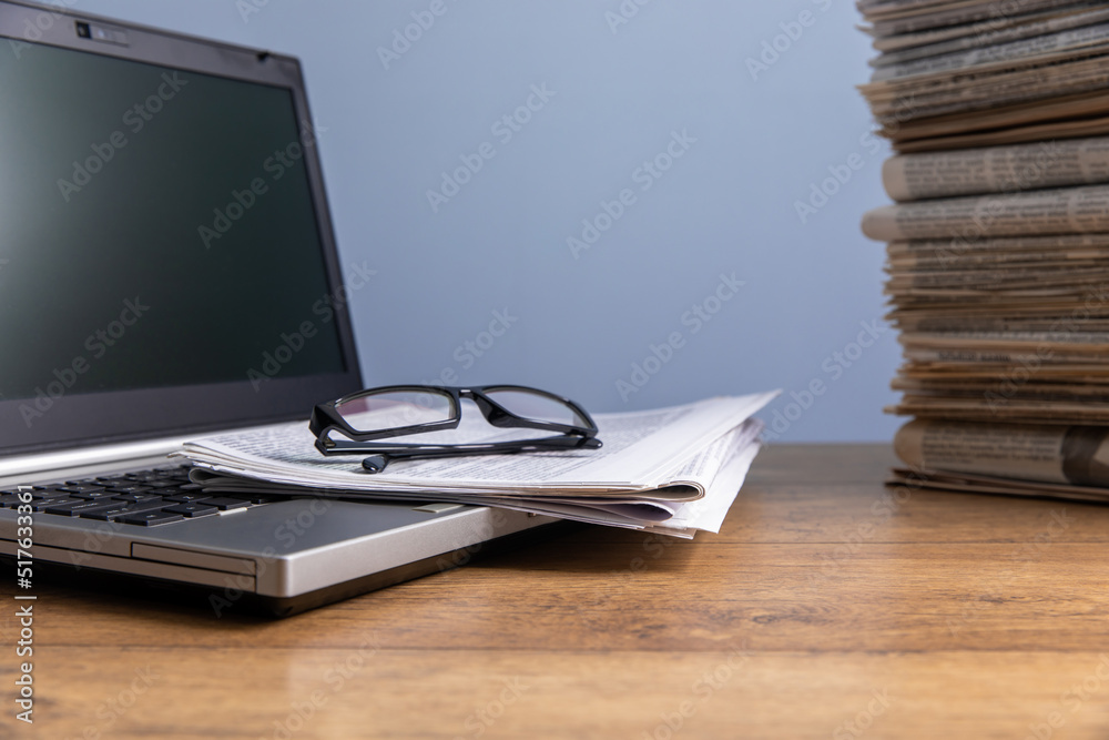 newspapers and glasses on notebook newspapers and glasses on notebook