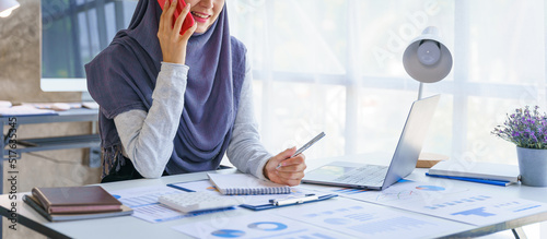 Photography Young muslim woman working in business office, wearing Hijab works as start up SMEs project, using phone, call a phone