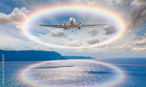 Old metallic propeller airplane in the sky with rainbow