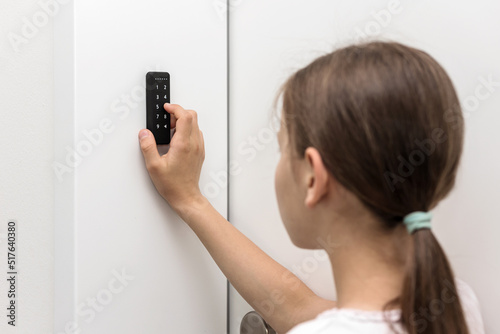 Electronic Code Lock near entrence door. Security keypad entry door lock. Girl entering security system code.   photo