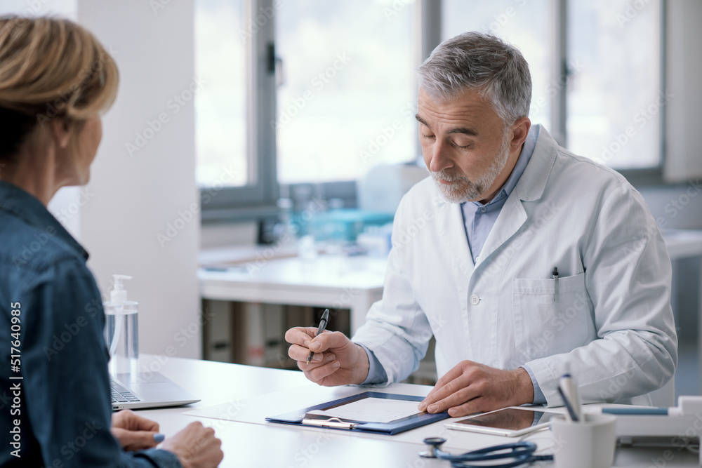 Doctor writing a medical prescription for his patient