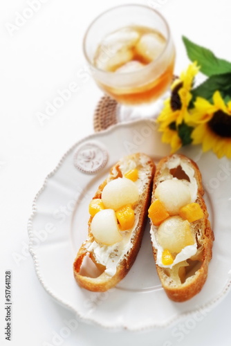 Homemade fruit and cream cheese French bread open sandwiches, white melon and mango with English black tea