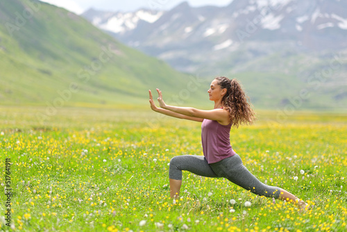 Woman practicing tai chi in a high mountain field photo