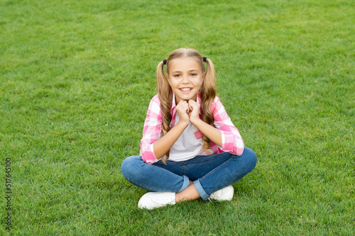 cheerful teen kid sit on green grass outdoor © be free