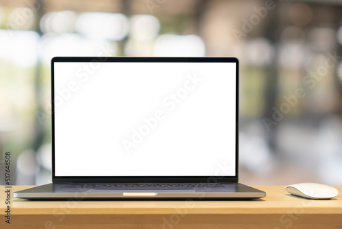 Laptop with blank screen on wood table with cafe coffee shop blur background