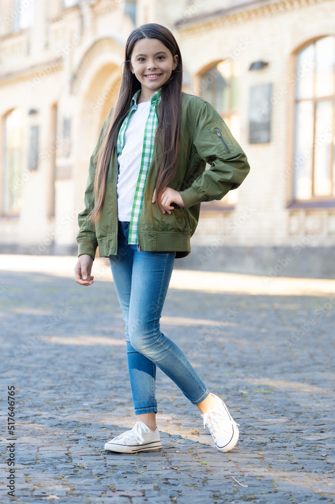 Fototapeta premium Happy girl teenager posing in casual trendy style outdoors, fashion