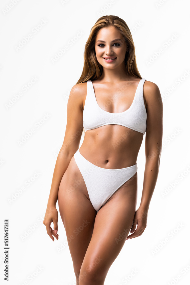 Smiling sporty woman in white underwear posing on studio background with copy space. Female beauty, sport, spa concept Smiling sporty woman in white underwear posing on studio background with copy space. Female beauty, sport, spa concept
