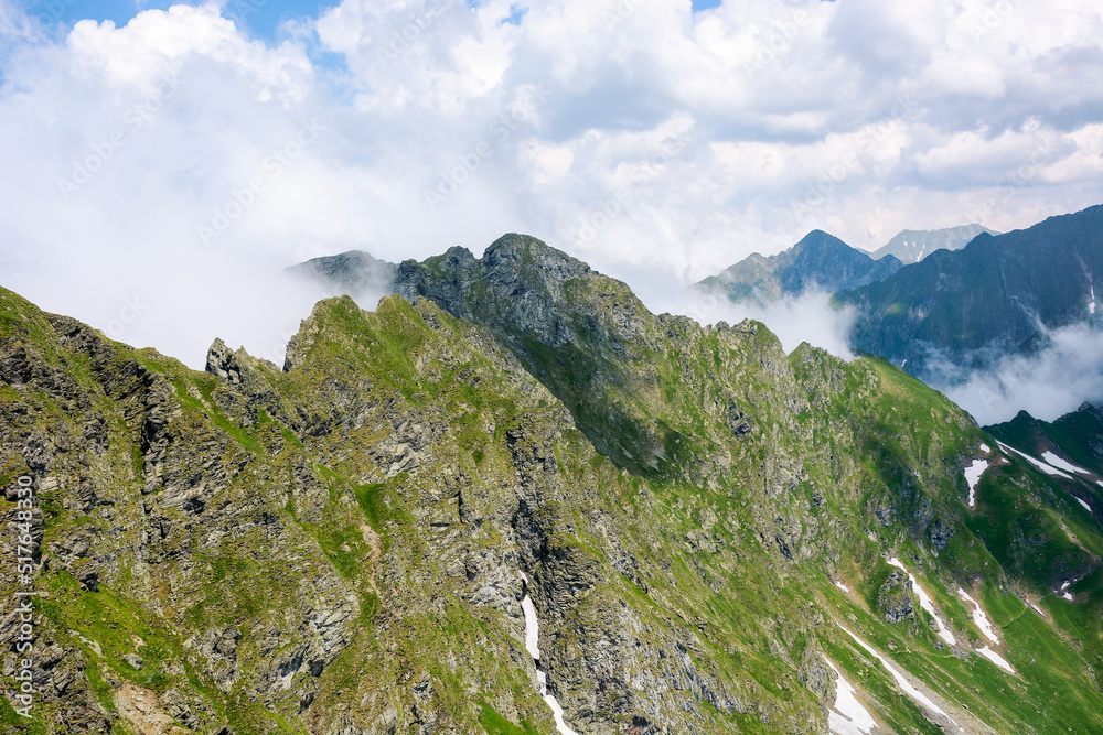 beautiful fagaras ridge on a sunny morning. popular destination in mountain range of romania. rocky cliffs and clouds in morning light. wonderful nature background