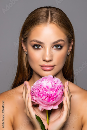Skincare of young beautiful woman face with fresh flower over white background