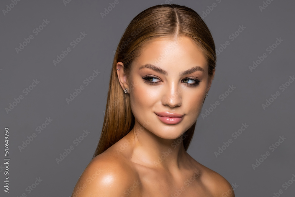 Beautiful smiling girl with clean skin, natural make-up, and white teeth isolated on grey background Beautiful smiling girl with clean skin, natural make-up, and white teeth isolated on grey background