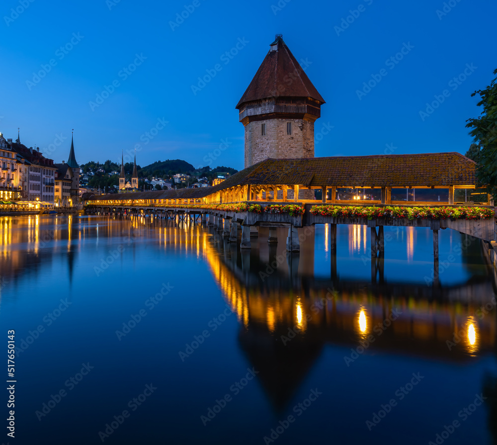 Image of Lucerne, Switzerland, with the famous historical wooden Chapel bridge, during twilight blue hour.