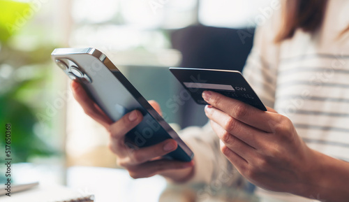 Woman hand holding credit cards and using smartphone for shopping online with payment on internet banking.