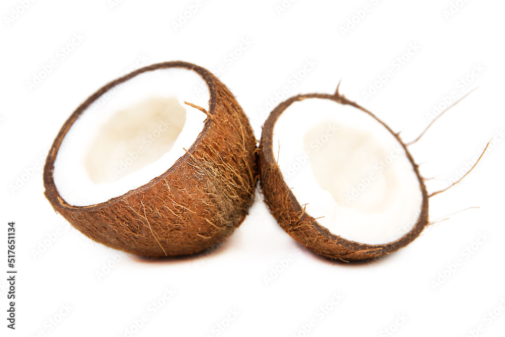Two halves of split ripe organic coconut isolated on white background.