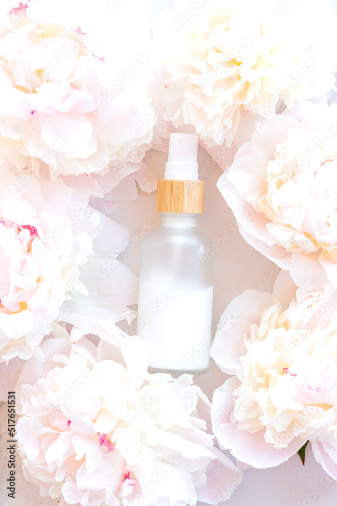 White Cream bottle and peony flowers background. Cosmetic skincare product blank frosted glass package. White bottle of unbranded lotion, balsam, hand creme mockup, flat lay. White Cream bottle and peony flowers background. Cosmetic skincare product blank frosted glass package. White bottle of unbranded lotion, balsam, hand creme mockup, flat lay.