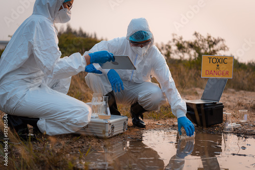 Ecologist taking samples of water with test tube from city river to determine level of contamination and pollution, Research conserve water and environment.