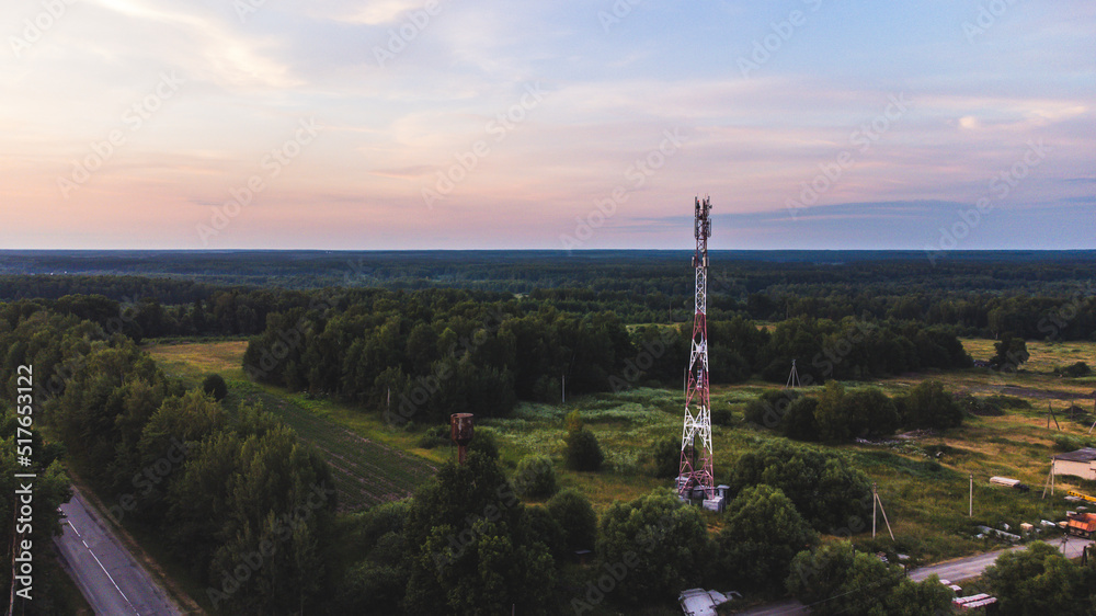 cell tower in the evening against the background of the forest and sky