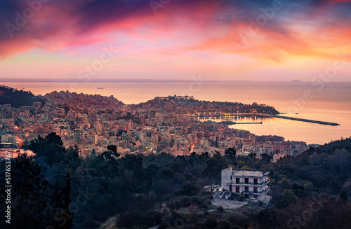 Pink morning light on Aegean Sea. Aerial morning view of Kavala city. Calm sunrise in Greece, Europe. Traveling concept background..